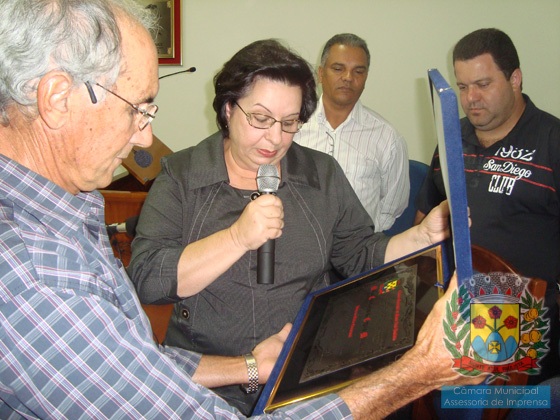 Leitura do título pela homenageada, durante a sessão solene presidida pelo vereador Nardo Gurjon, secretariado pelos vereadores Fabinho e Toninho 